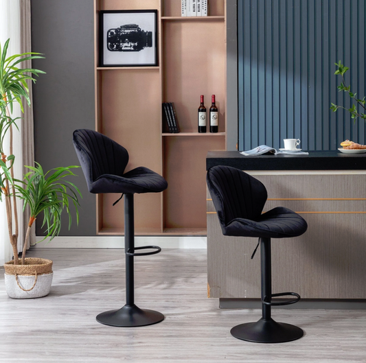 Two black velvet Jardene bar stools in a modern kitchen setting with a shelf and plants.