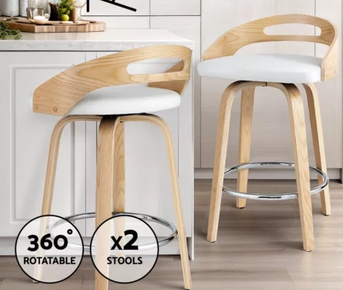 Raquel Two bar stools with wooden frames and white seats in a kitchen setting.