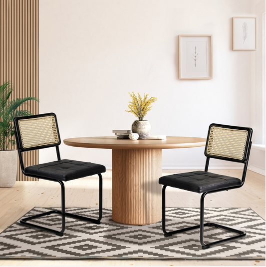 Steph dining area with a wooden table and black chairs on a patterned rug.